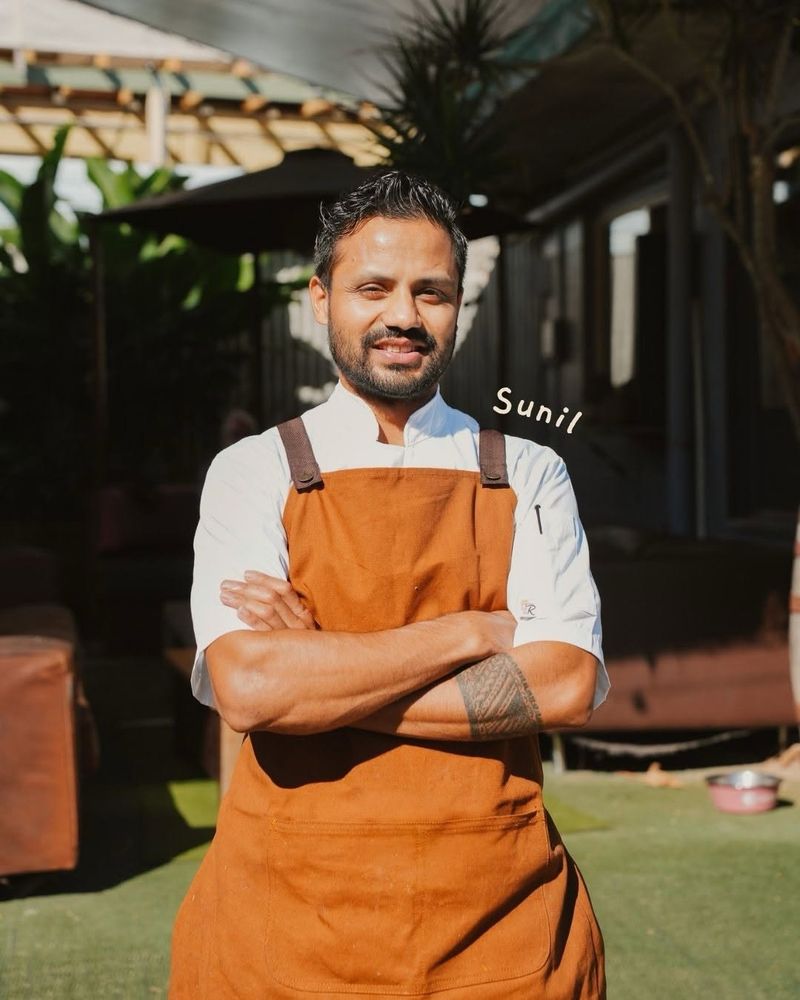 Chef Sunil in his apron in the Salt & Stone garden