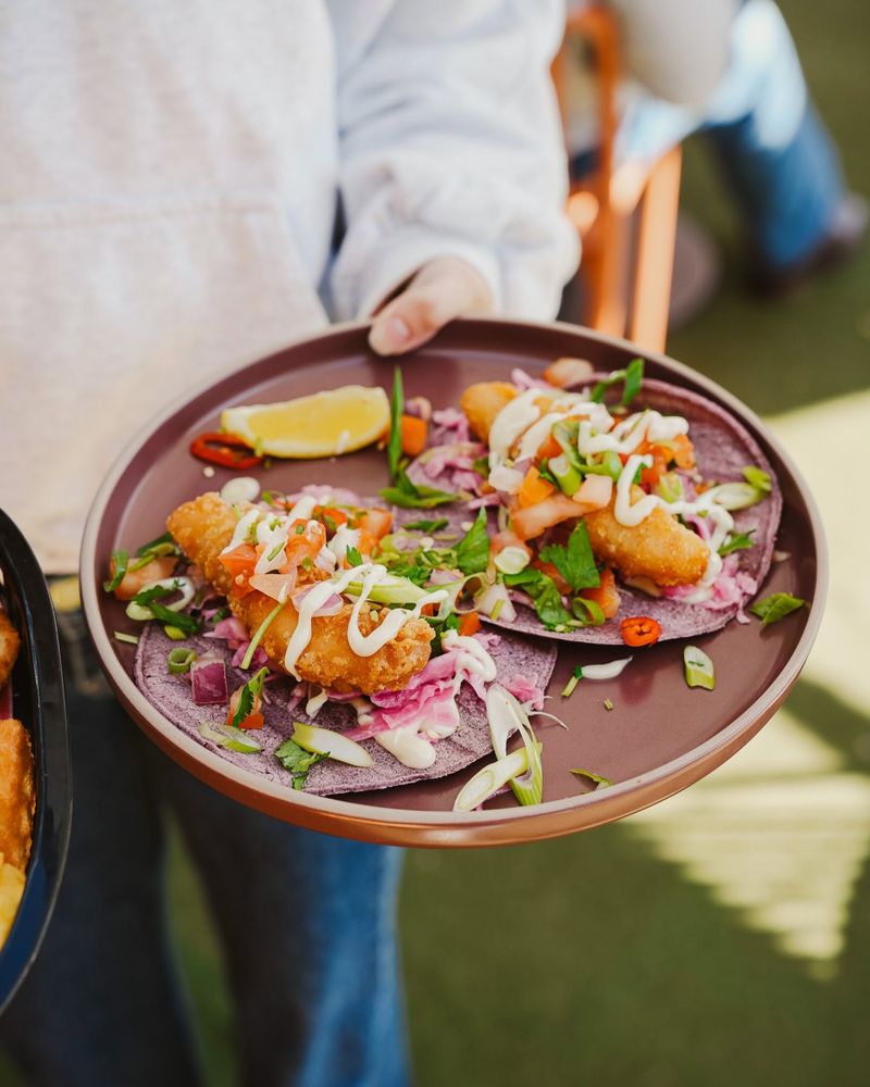 A plate of fish tacos being served
