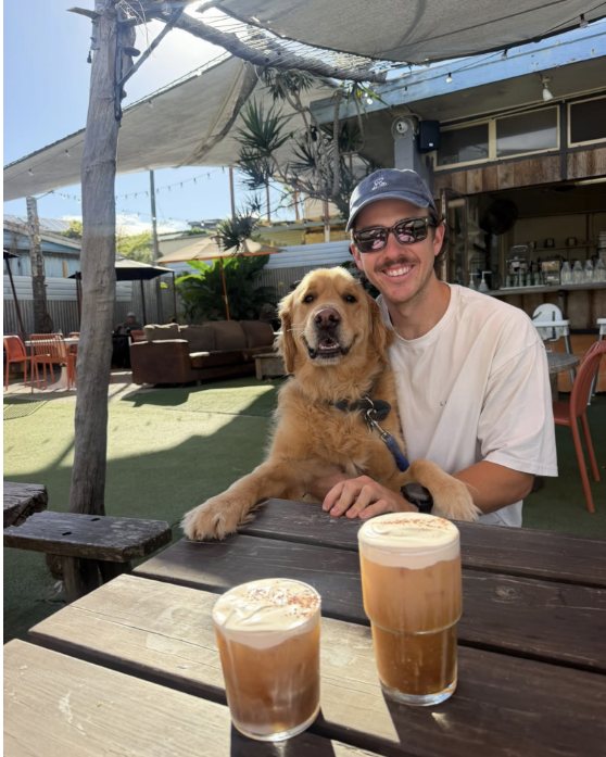 A local and his golden retriever with iced coffees in the garden