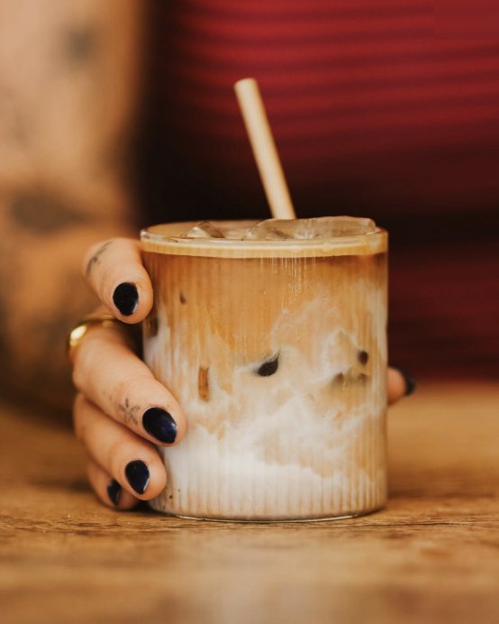 An iced latte in a ribbed glass