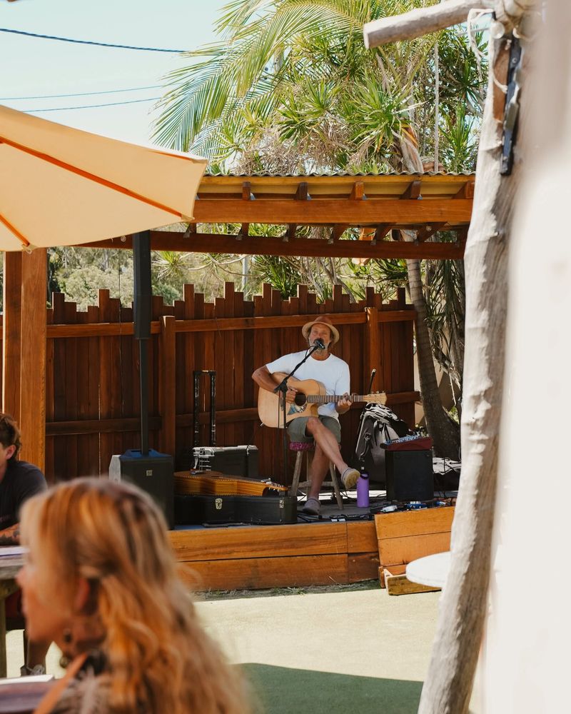 A musician playing guitar on the Salt & Stone stage